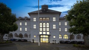 Un grand bâtiment blanc doté de nombreuses fenêtres et d’une entrée centrale.