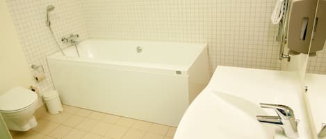 A bathroom with a bathtub, toilet, and sink.