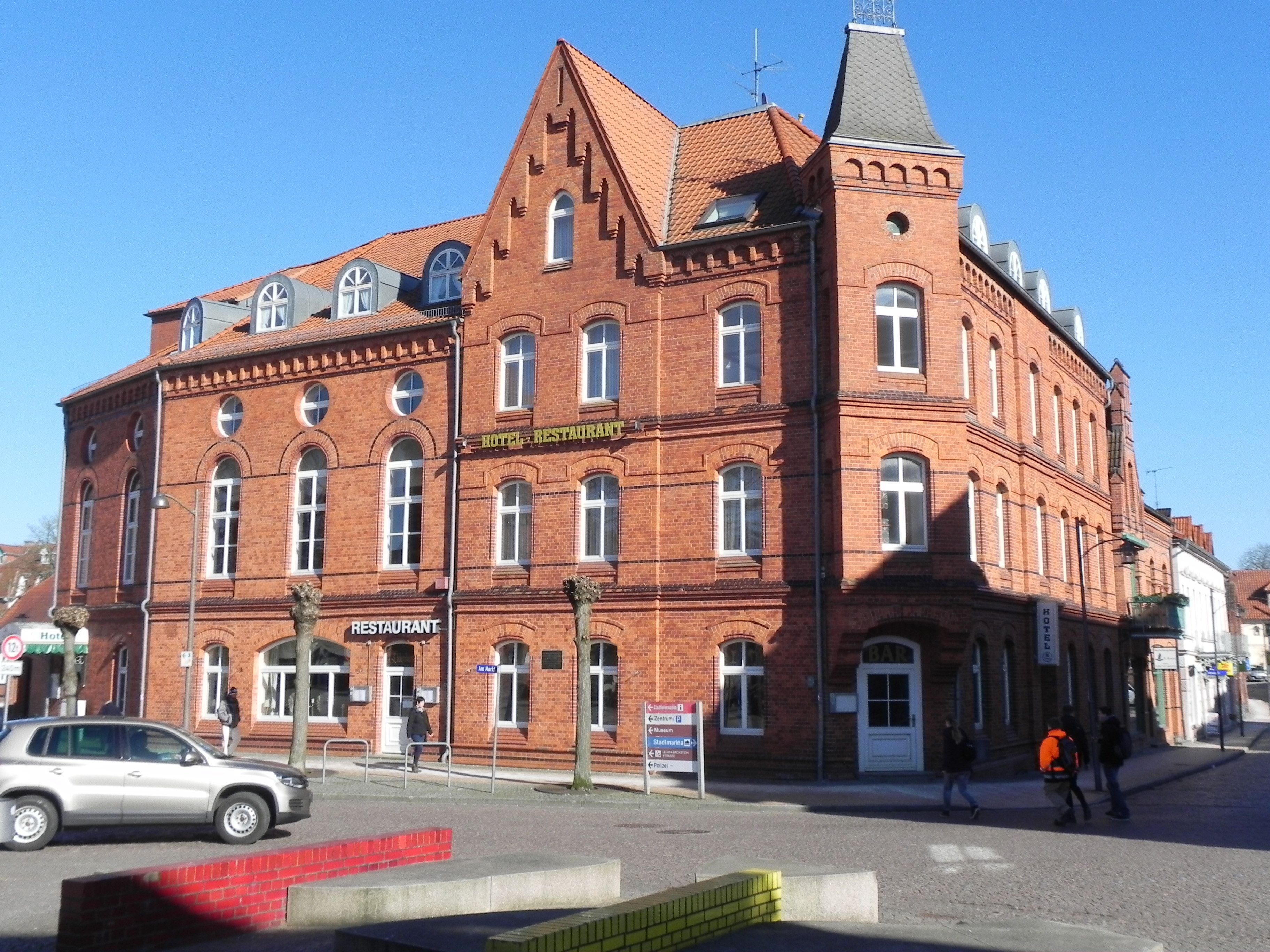 A red brick building with a sign indicating it is a hotel and restaurant.