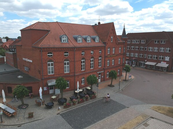 A red brick building with multiple windows and a sign indicating it houses a restaurant. - Hotel Zur Eldenburg (Luebz)
