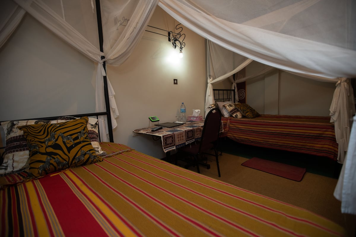 A room with two beds, a desk, and a chair.