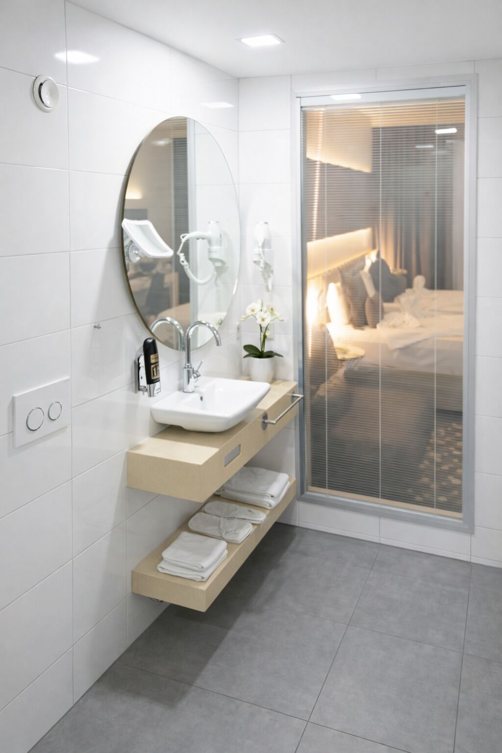 Un baño moderno con un espejo grande, un lavabo y un perchero para toallas.