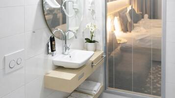 Un baño moderno con un espejo grande, un lavabo y un perchero para toallas.
