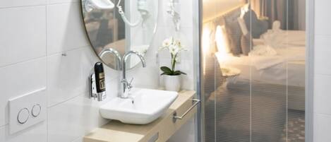 Un baño moderno con un espejo grande, un lavabo y un perchero para toallas.