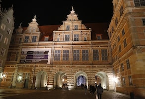 A historic building with a grand entrance, large arched doorways, and classical architecture.