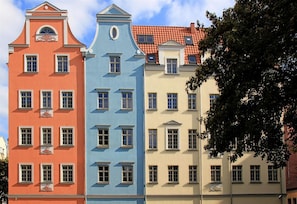 Una hilera de edificios de tres pisos, con diseños de ventanas uniformes y un estilo arquitectónico consistente.