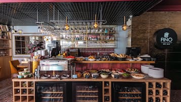 A bar area with a wine cooler, shelves with bottles, and a coffee machine.