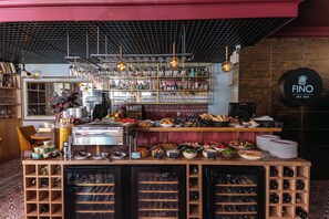 A bar area with a wine cooler, shelves with bottles, and a coffee machine. - Apart Neptun (Gdansk)