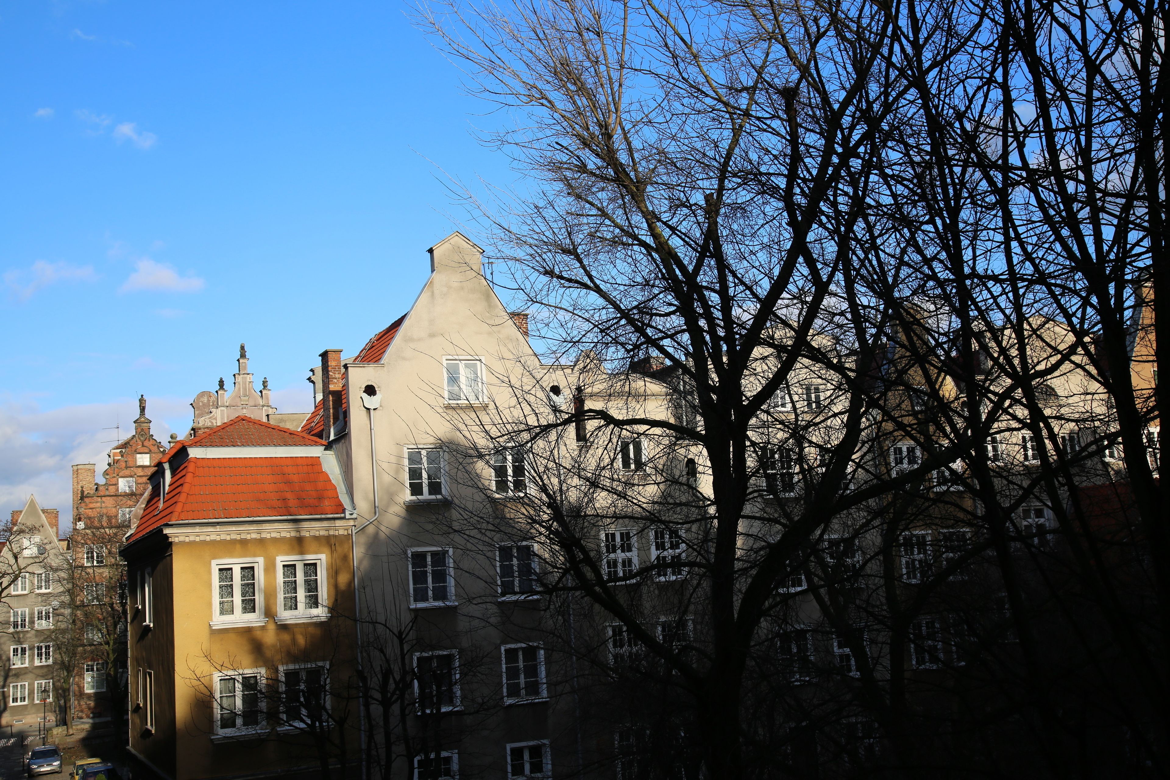 A row of traditional European buildings with uniform window patterns and red-tiled roofs.