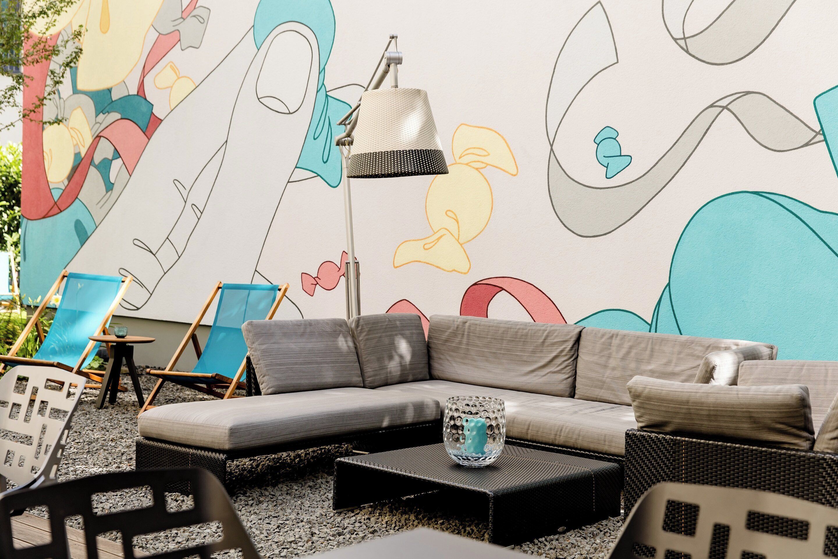 A modern living room with a sectional sofa, a floor lamp, and a decorative glass vase.