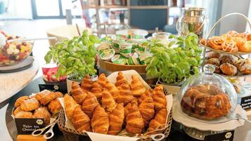 Eine Auswahl an Gebäck und Desserts, darunter Croissants und Muffins, in einem Café.