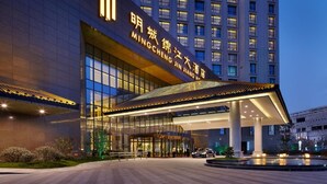 A modern hotel entrance with a large glass facade and illuminated signage. - Jin Jiang MingCheng Hotel (Yancheng)