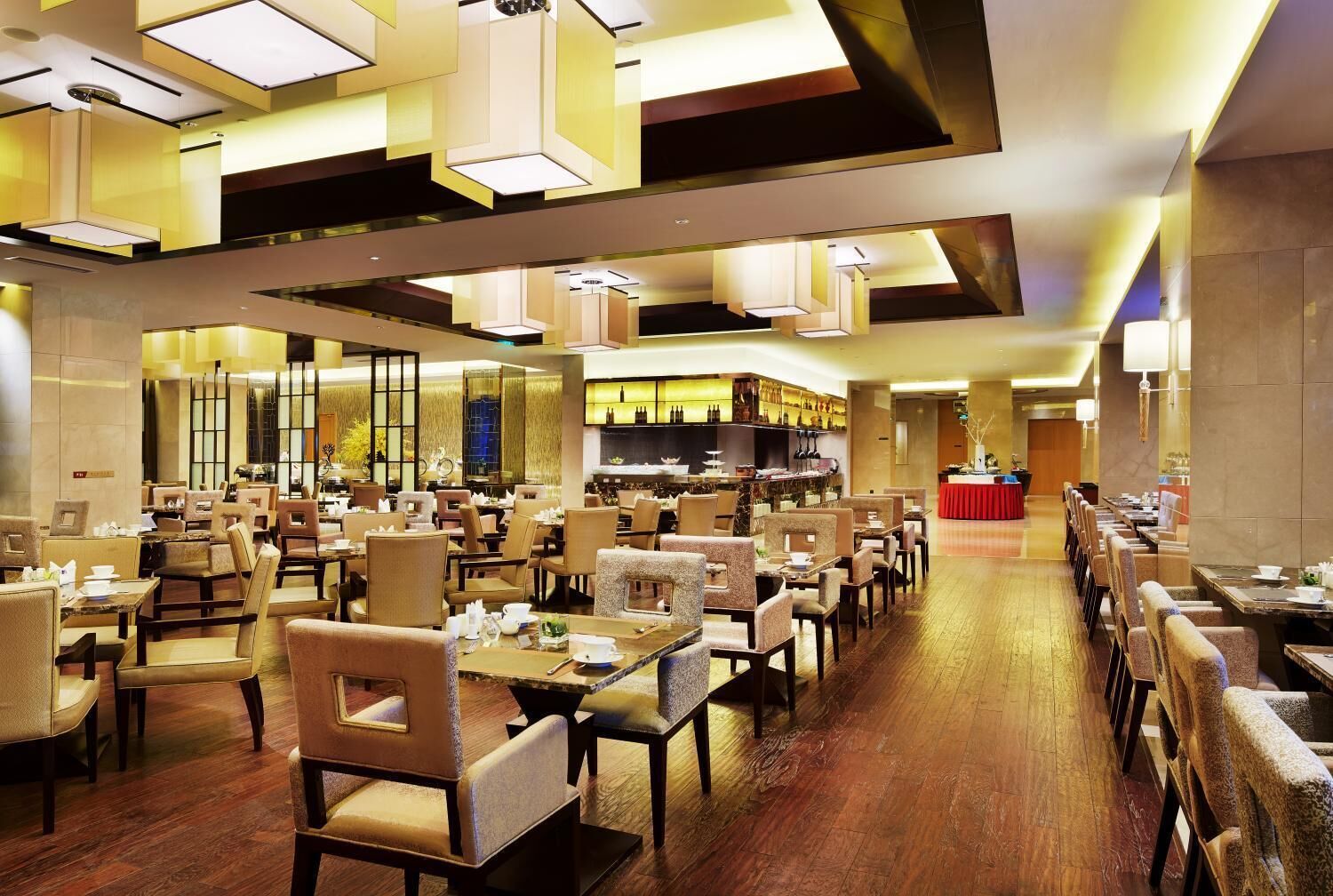 A spacious restaurant with multiple dining areas, high ceilings, and modern lighting fixtures.
