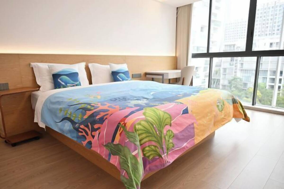 Una habitación de hotel con una cama, una mesita y una silla.