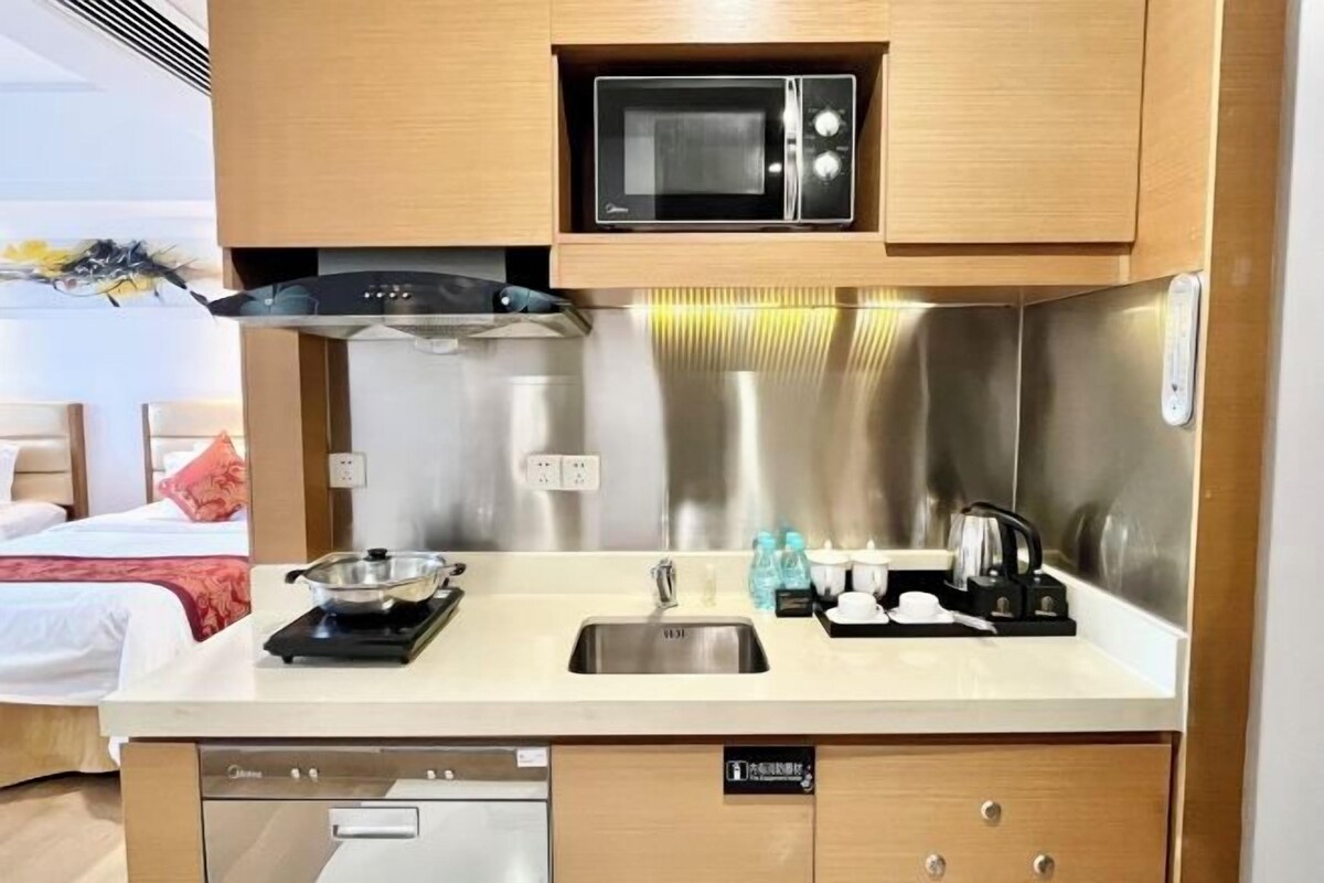 Une cuisine compacte équipée d’un four à micro-ondes, d’un évier et d’un lave-vaisselle.