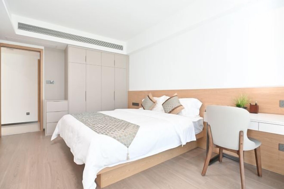 Une chambre à coucher moderne, avec un lit, un bureau et une chaise.