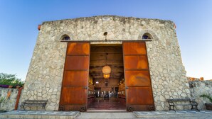 A stone building with large wooden doors and a checkered floor. - Narbona Wine Lodge (Carmelo)