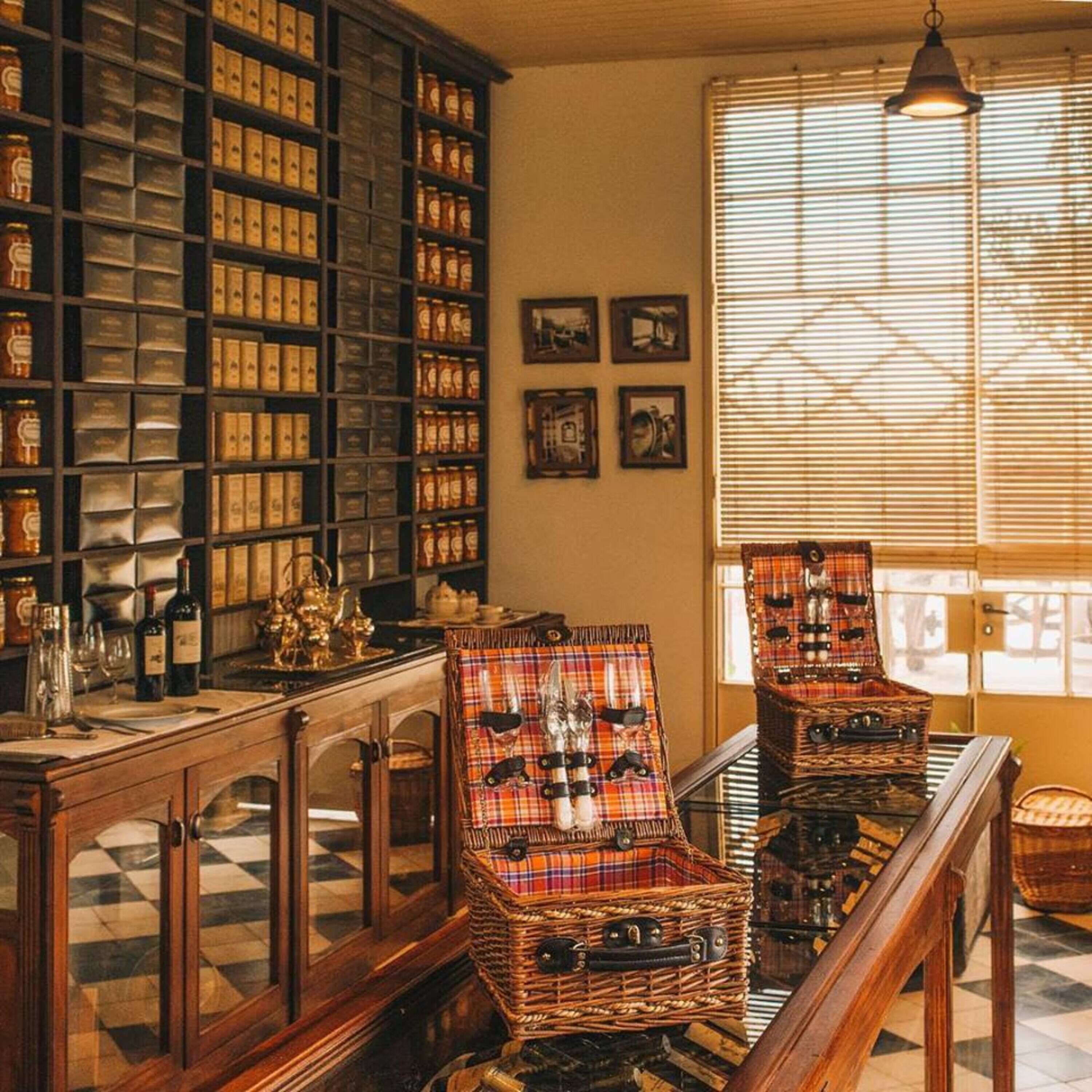 A library with bookshelves, a piano, and wicker chairs.