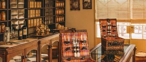 A library with bookshelves, a piano, and wicker chairs.