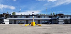 A motel with a central entrance, multiple rooms, and a parking area.