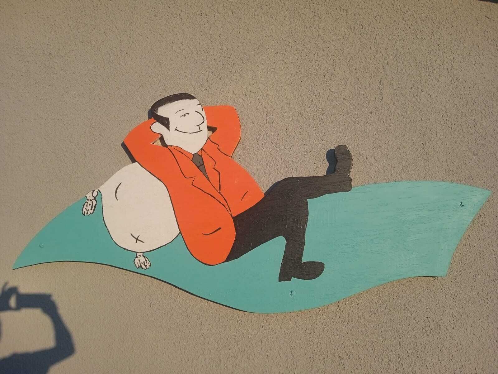 A cartoon character sitting on a curved surface.