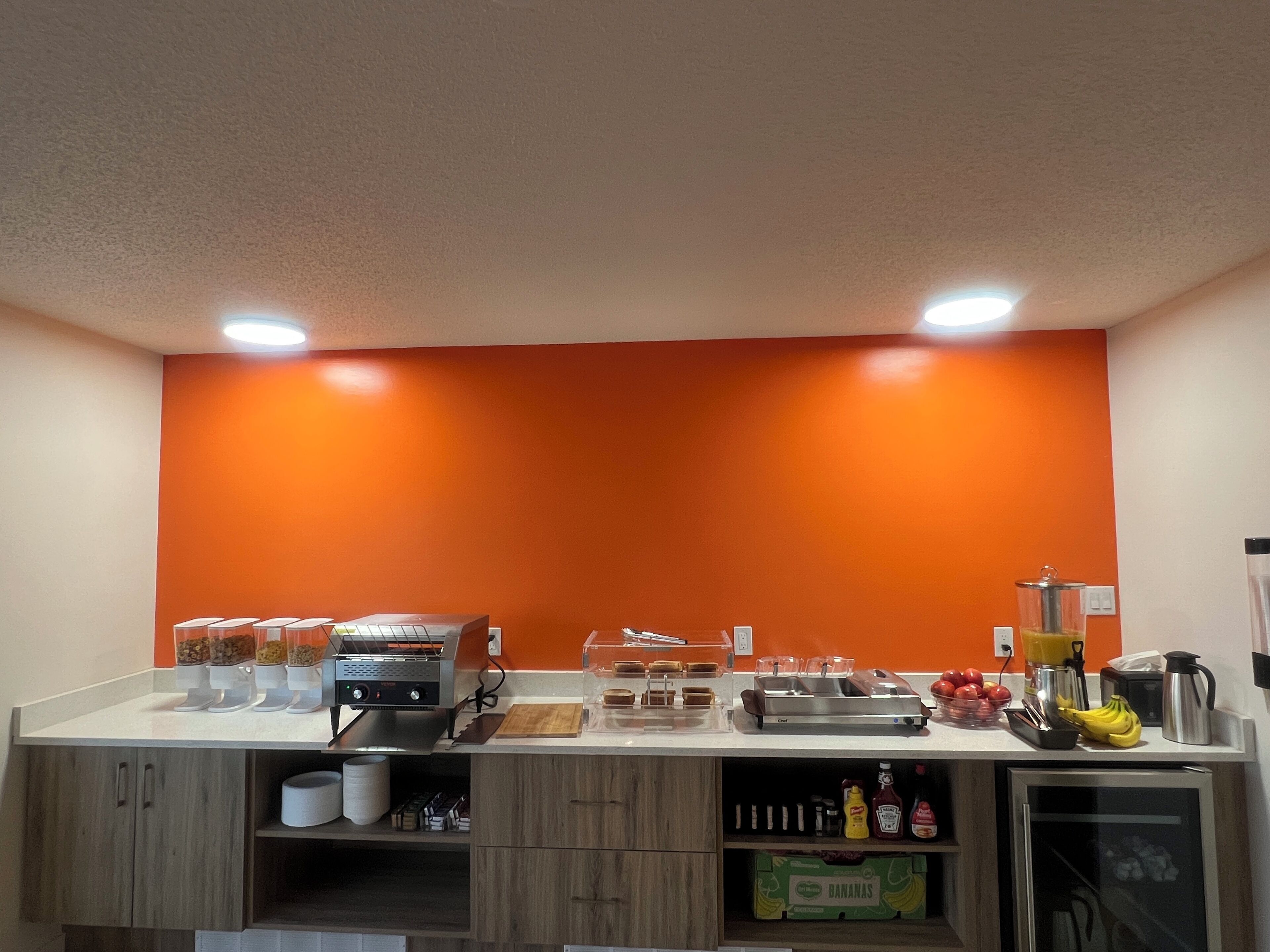 A kitchen with a white countertop, a toaster, a coffee maker, a blender, and a refrigerator.