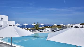 Una piscina al aire libre, sillones reclinables de piscina