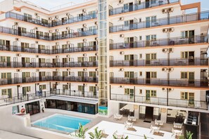 A multi-story hotel with balconies, a swimming pool, and outdoor seating areas. - Hotel Camposol (Benidorm)