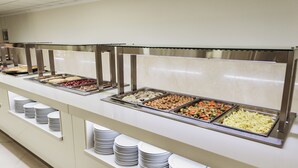 A buffet with various food items and stacked plates. - Hotel Camposol (Benidorm)
