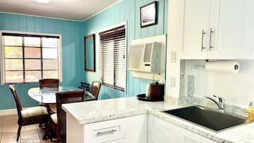 A kitchen with white cabinets, a marble countertop, and a sink.