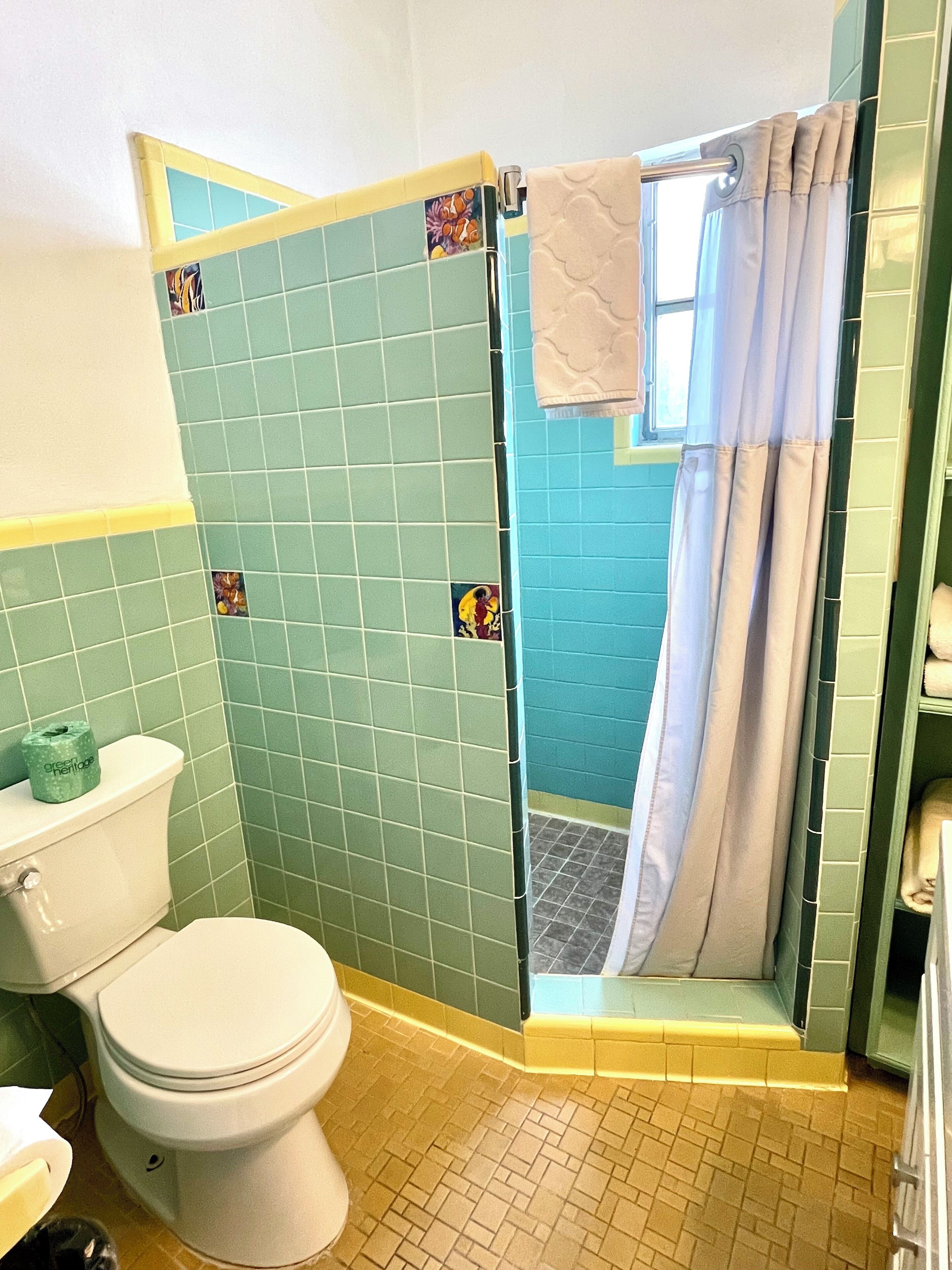 Uma casa de banho com sanita, área de duche e lavatório.