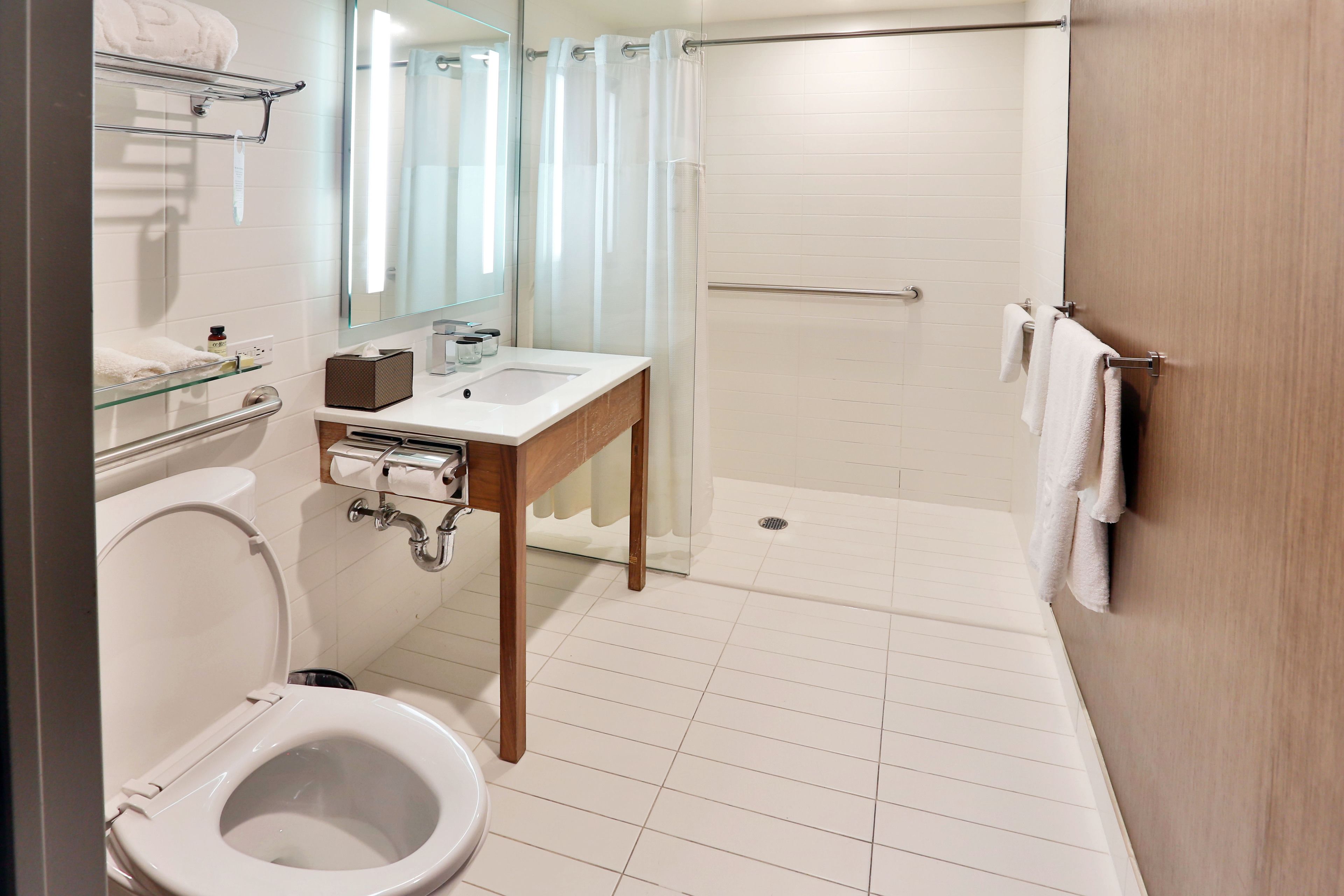 Een moderne badkamer met toilet, wastafel en douche.
