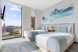 A hotel room with two beds, a large window with a city view, a painting on the wall, and a flat-screen TV mounted on the wall. - The Parc Hotel (Flushing)
