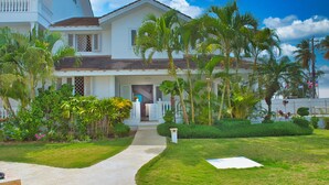 A two-story house with a balcony, surrounded by lush greenery and palm trees. - Villa Chiara Las Terrenas (Las Terrenas)