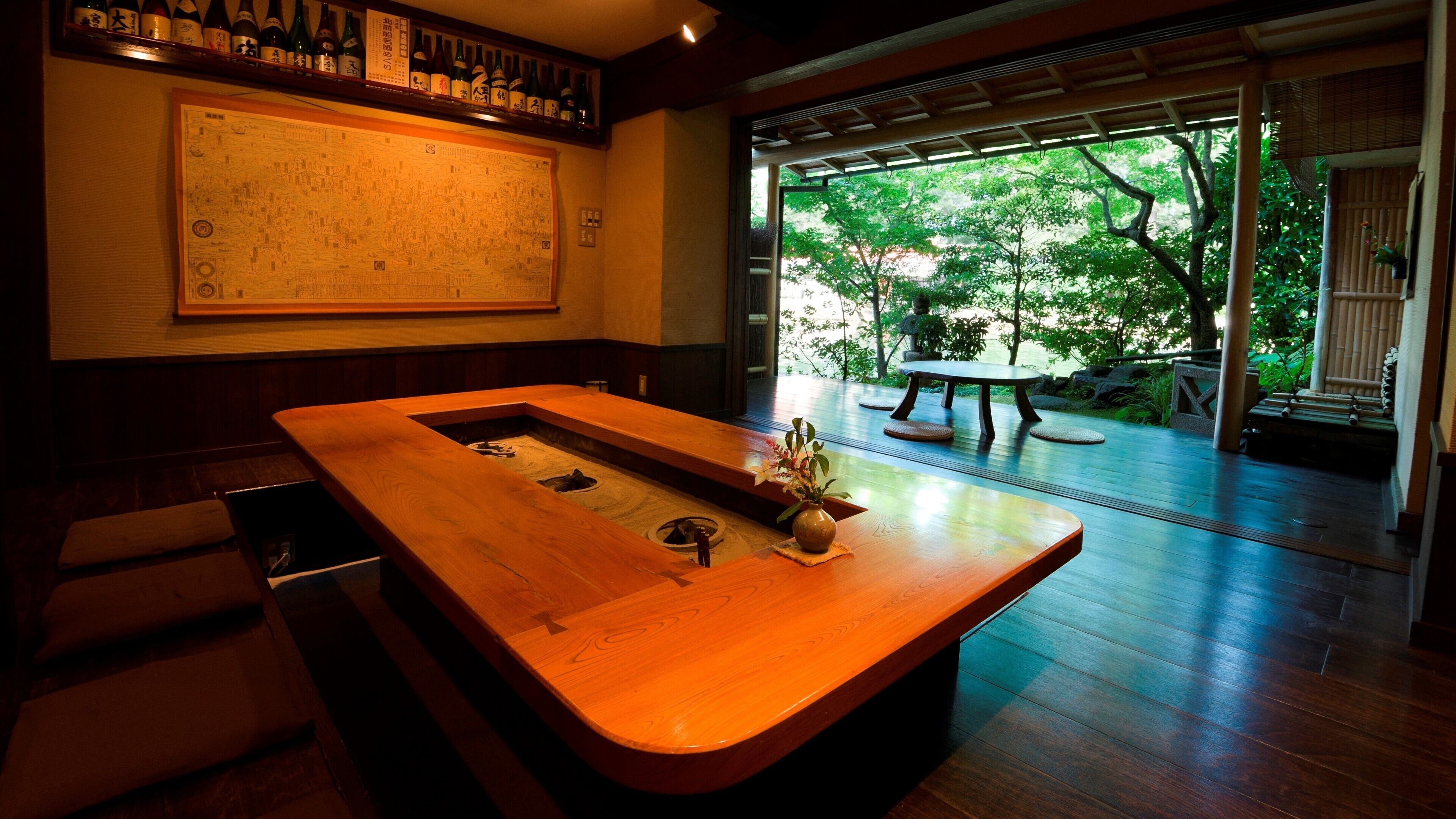 A wooden table with a vase of flowers, a wooden bench, and a large map on the wall.