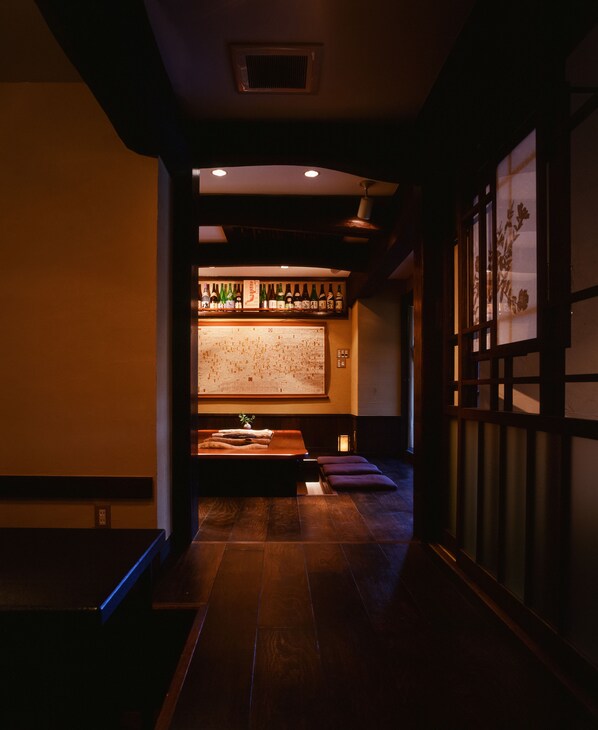 A traditional Japanese room with tatami flooring, a low table with a cushion, and a shoji screen. - Taikyourou (Miyazu)