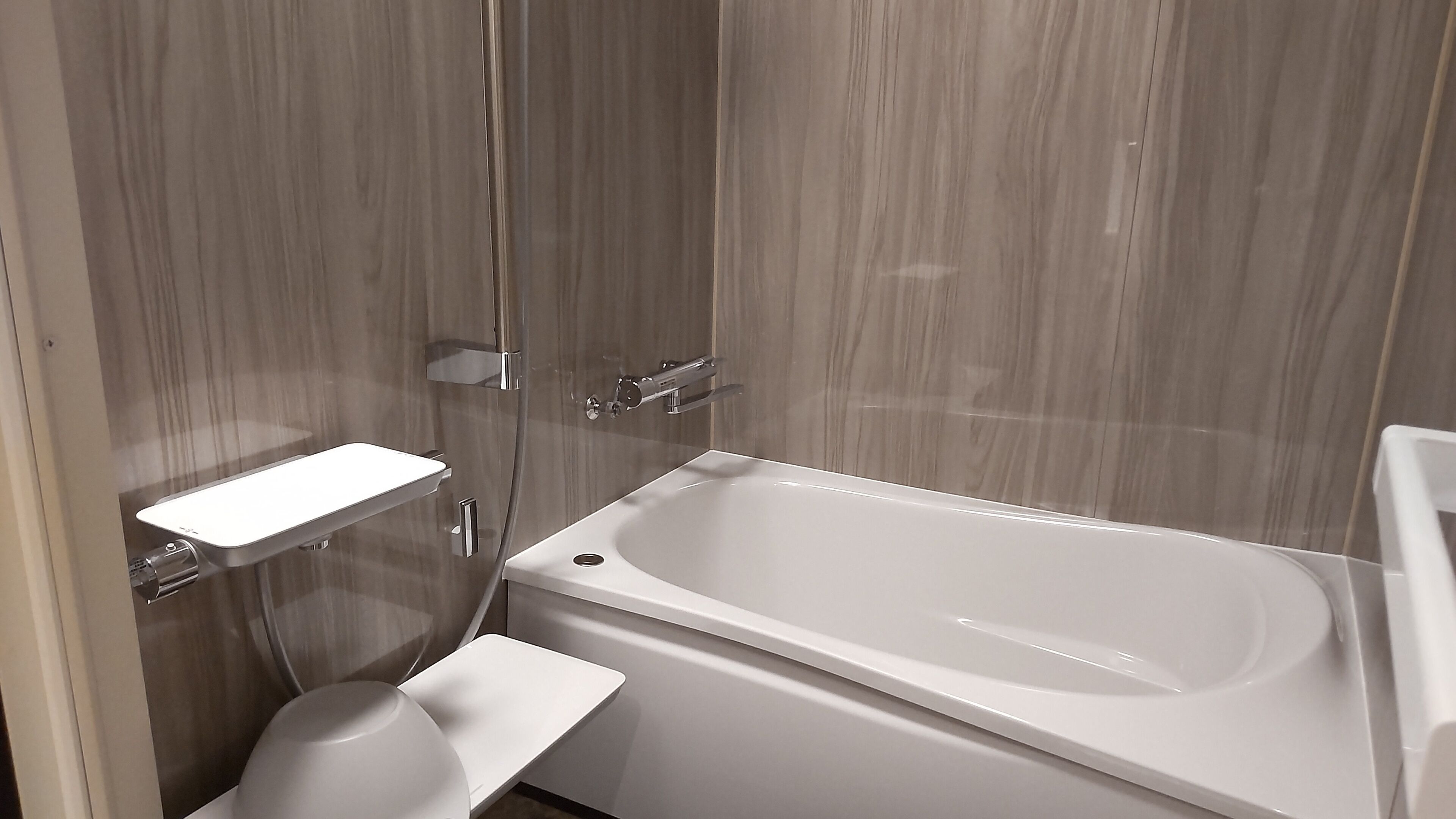 Un baño moderno con una bañera independiente, un inodoro y una cabina de ducha.
