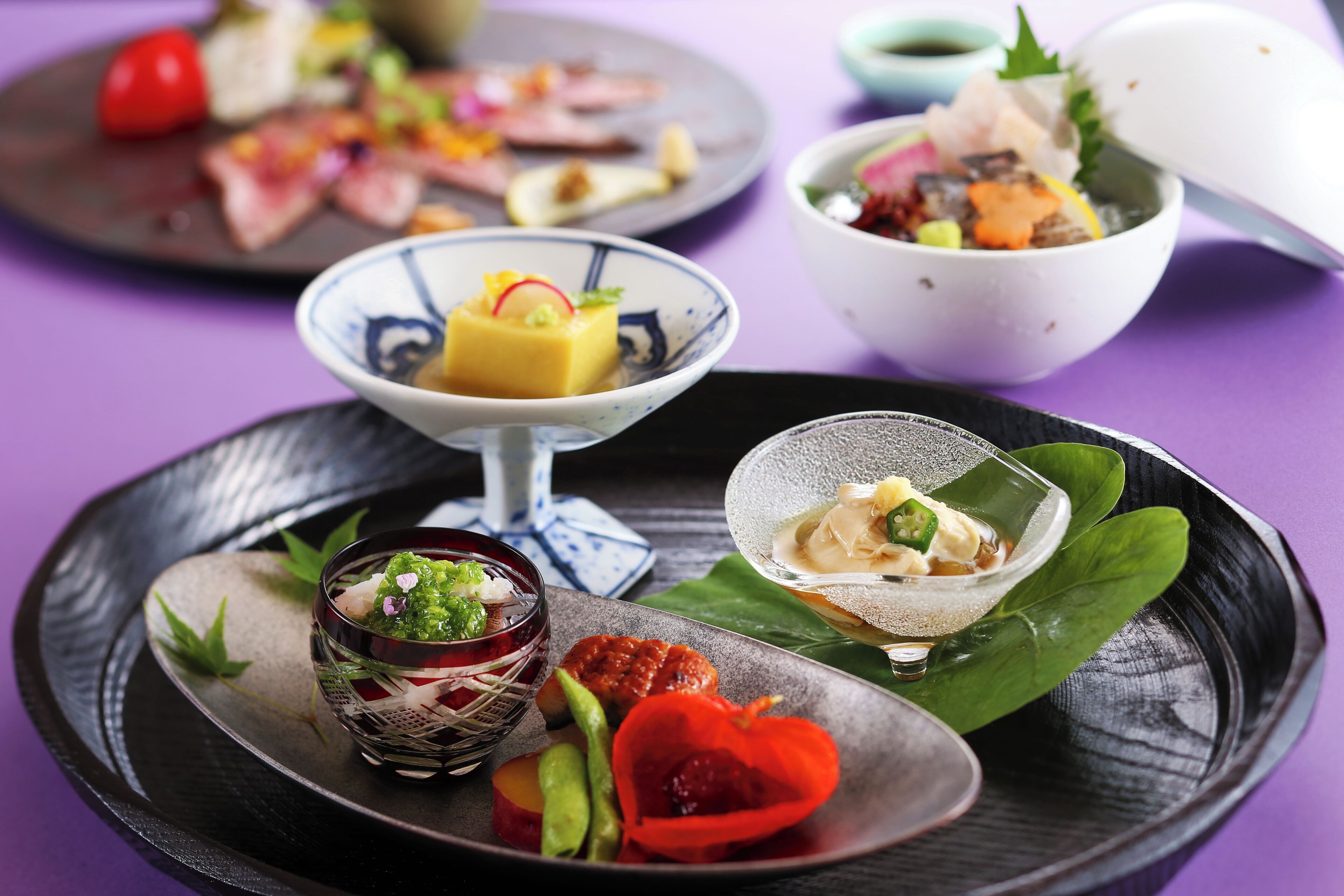 Variedad de platos sobre un plato negro con fondo morado.