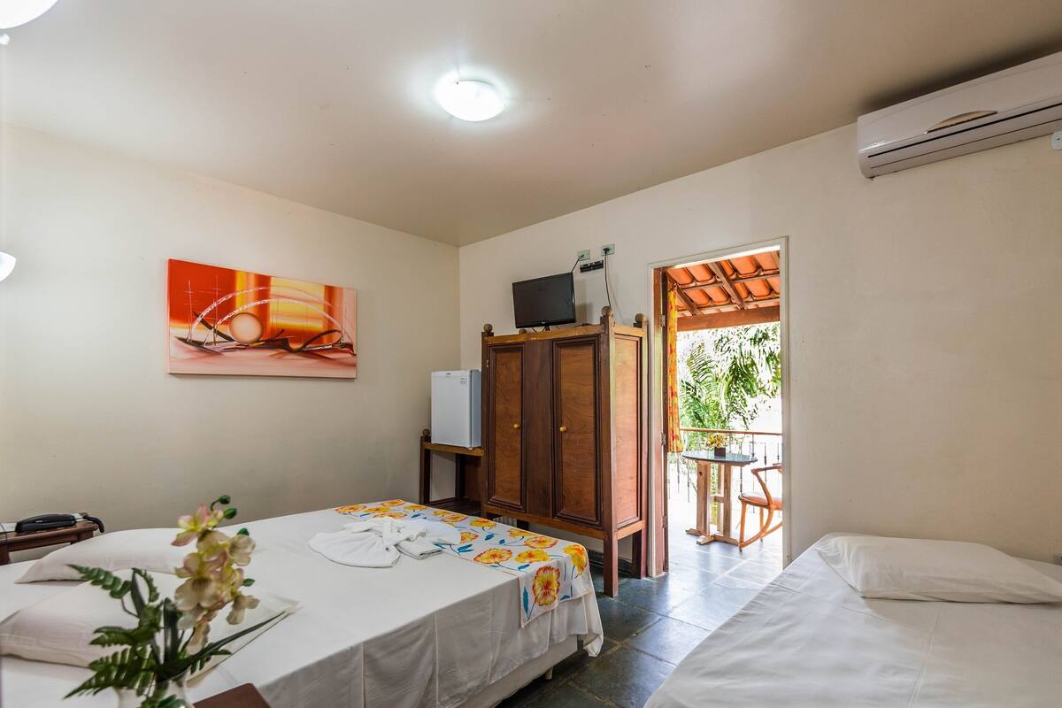 Une chambre d’hôtel avec un lit, un bureau équipé d’un ordinateur, une télévision et une vue sur l’extérieur.