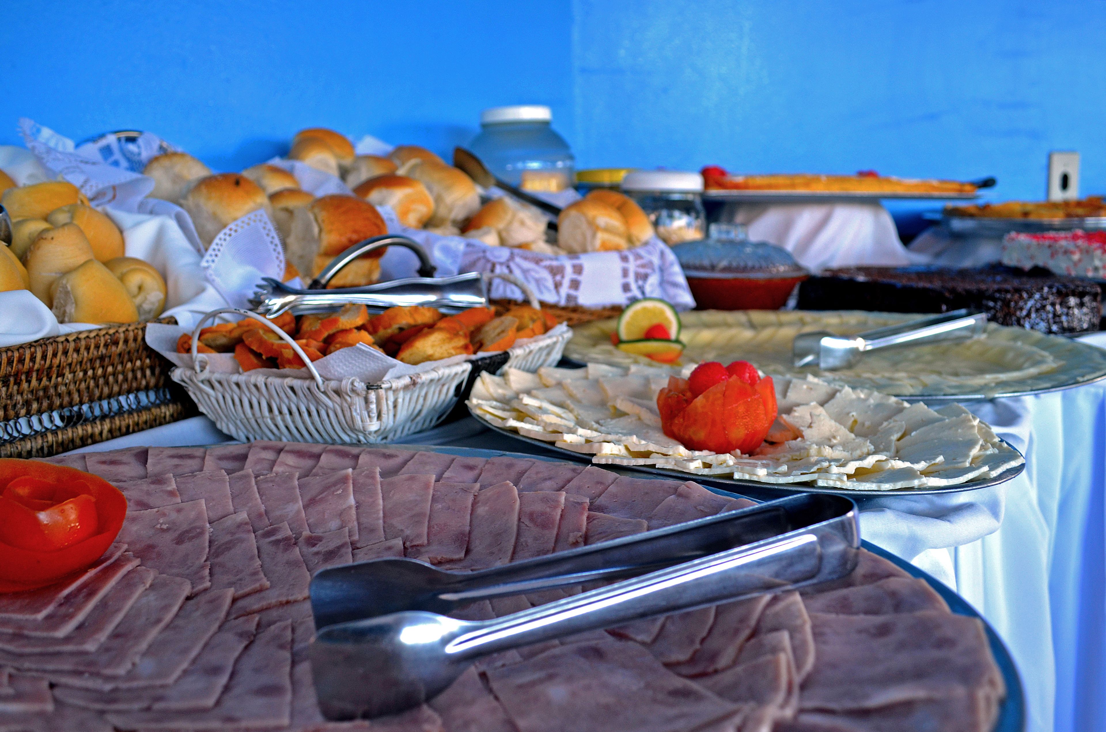A buffet table with various food items including sliced meats, bread, and vegetables.