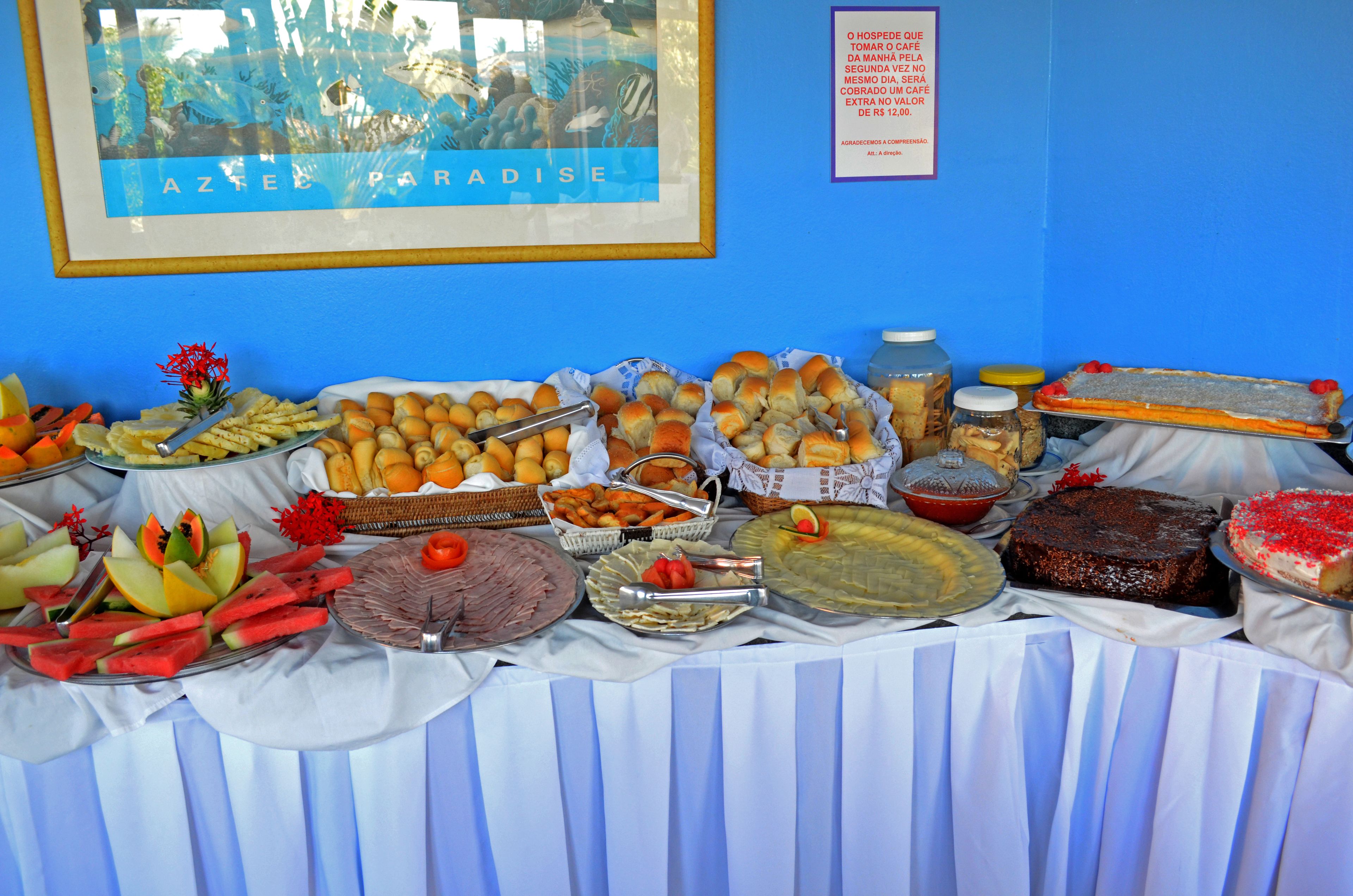 A buffet table with various food items and a framed picture on the wall.