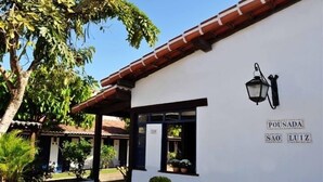 Un edificio blanco con techo de tejas rojas y un farol negro en la pared.
