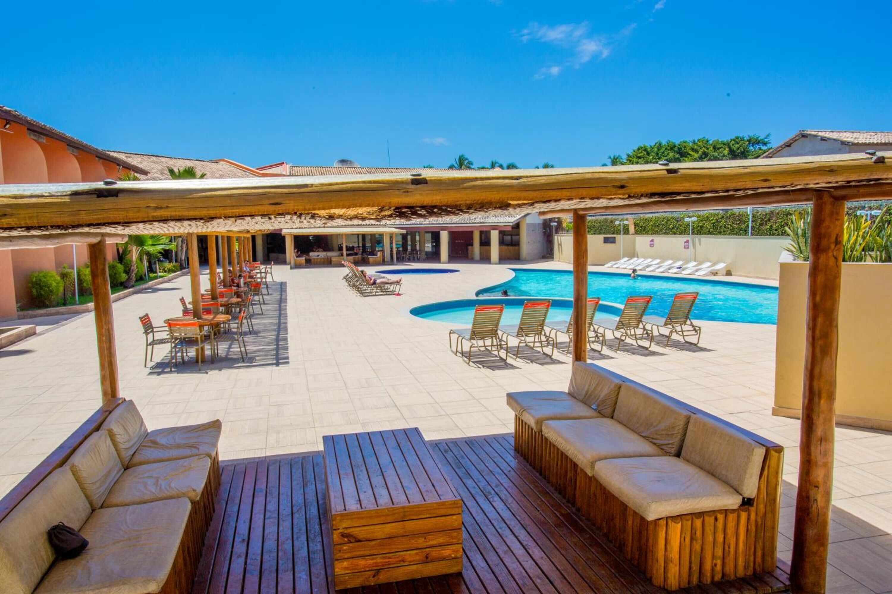 A pool area with lounge chairs and a wooden deck.