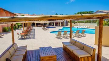 A pool area with lounge chairs and a wooden deck.