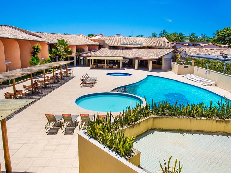 Een buitenzwembad, parasols bij het zwembad en ligstoelen