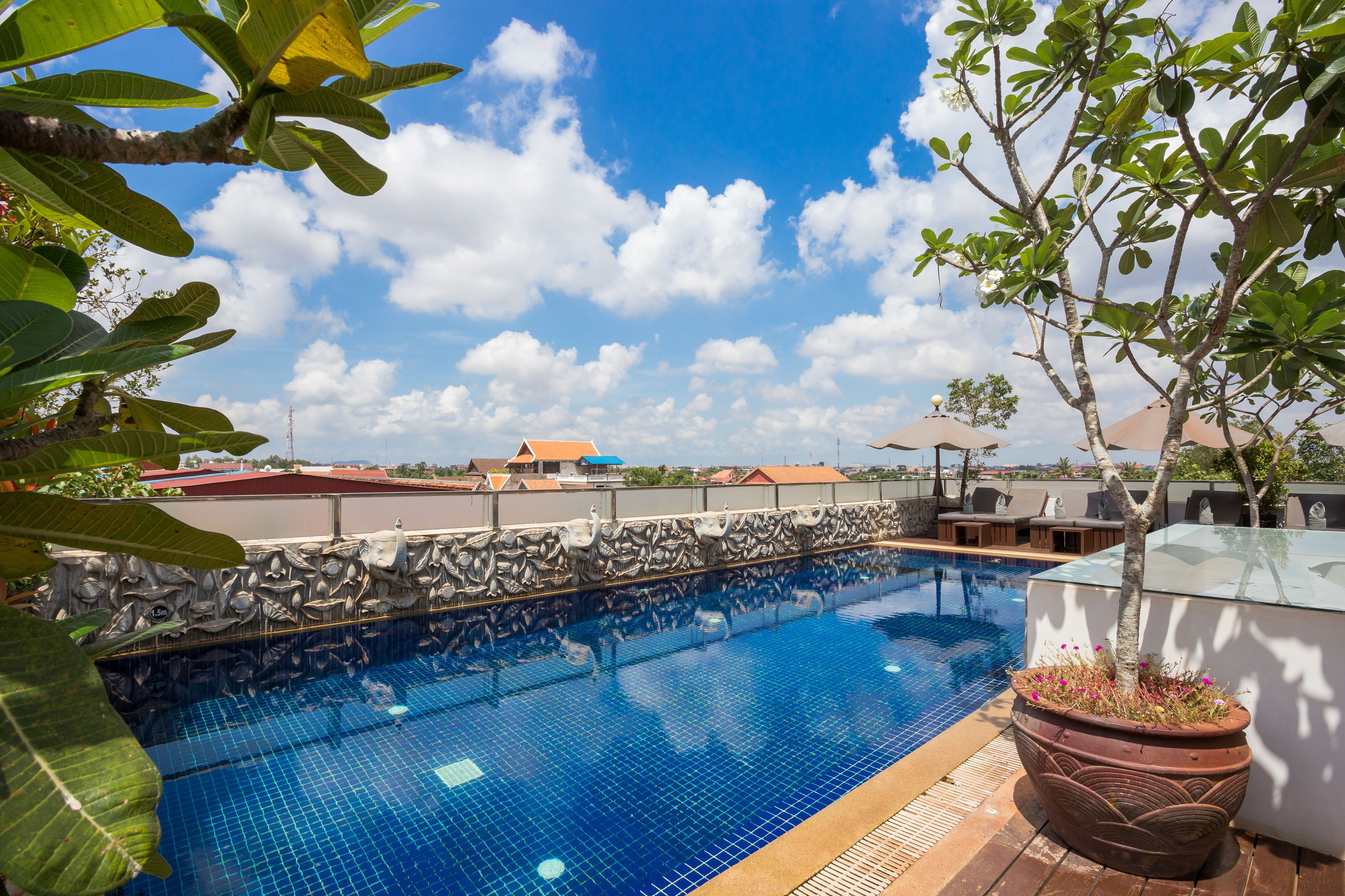 outdoor pool, a rooftop pool, pool umbrellas, pool loungers