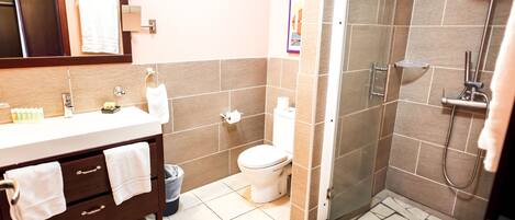 A bathroom with a shower, toilet, and vanity.