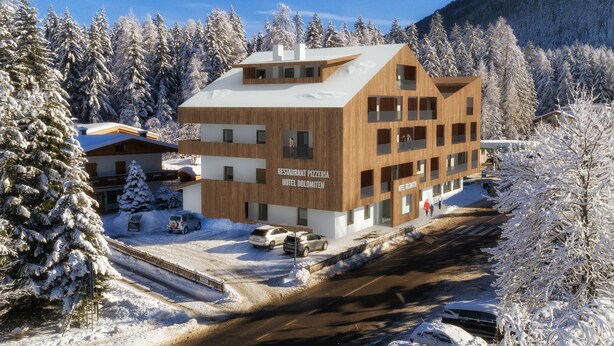 En moderne bygning med skilt for restaurant, pizzeria og hotel.