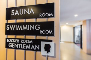 A sign with directions to the sauna, swimming, and locker room, including a gentleman's locker room. - Sriracha Orchid (Si Racha)