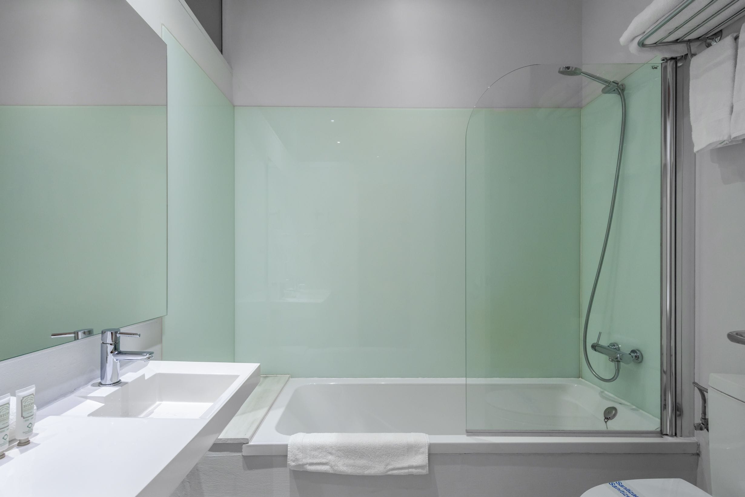 Un baño moderno con una bañera grande, zona de ducha separada y tocador con espejo.